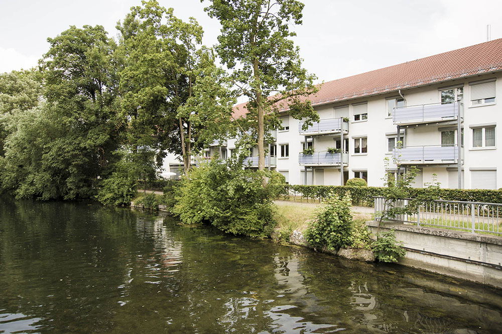 Eine Häuserreihe die nah am Fluss steht.