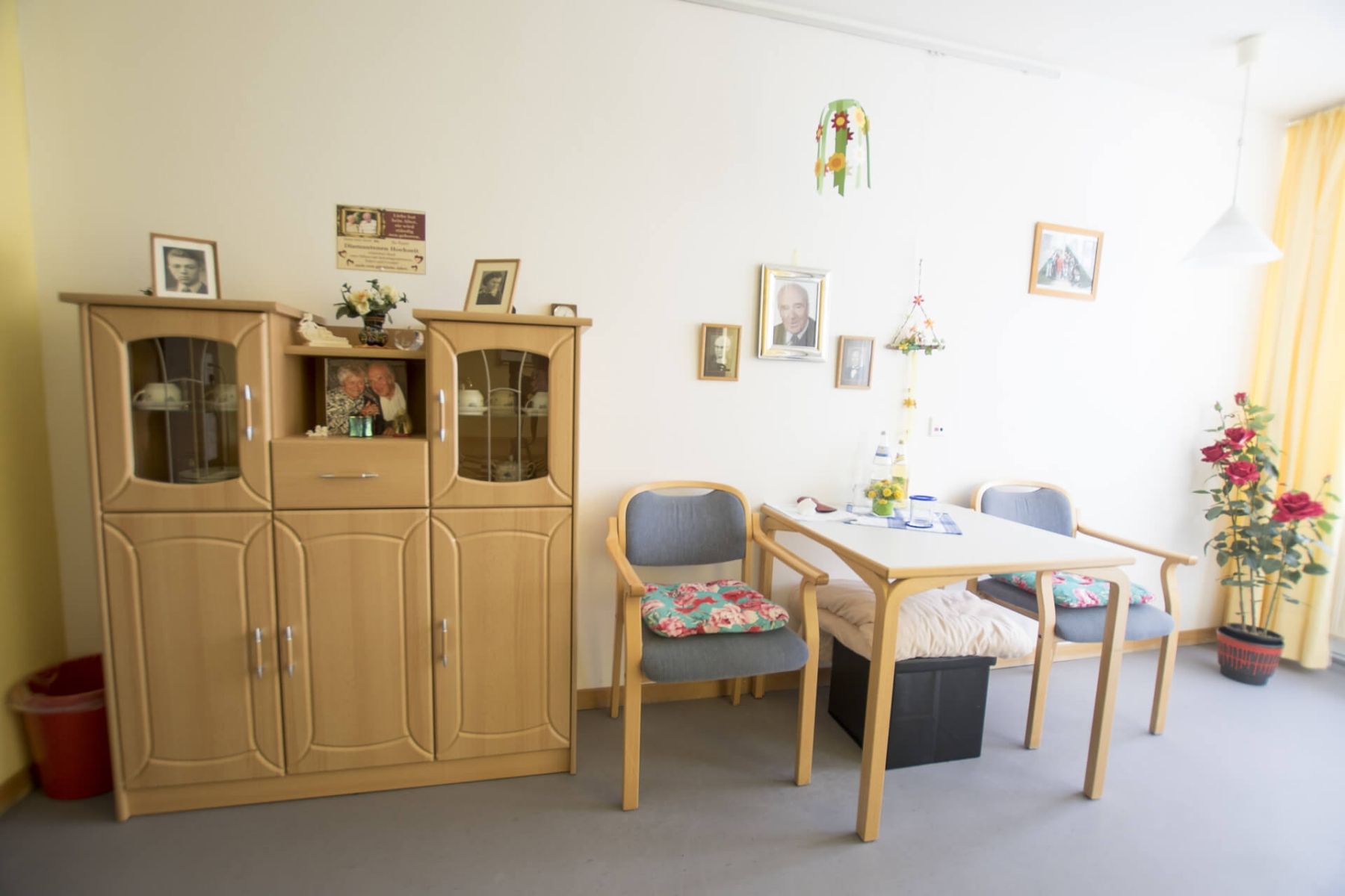 Gemütlich eingerichtetes Bewohnerzimmer mit persönlichen Fotos und Dekorationen.