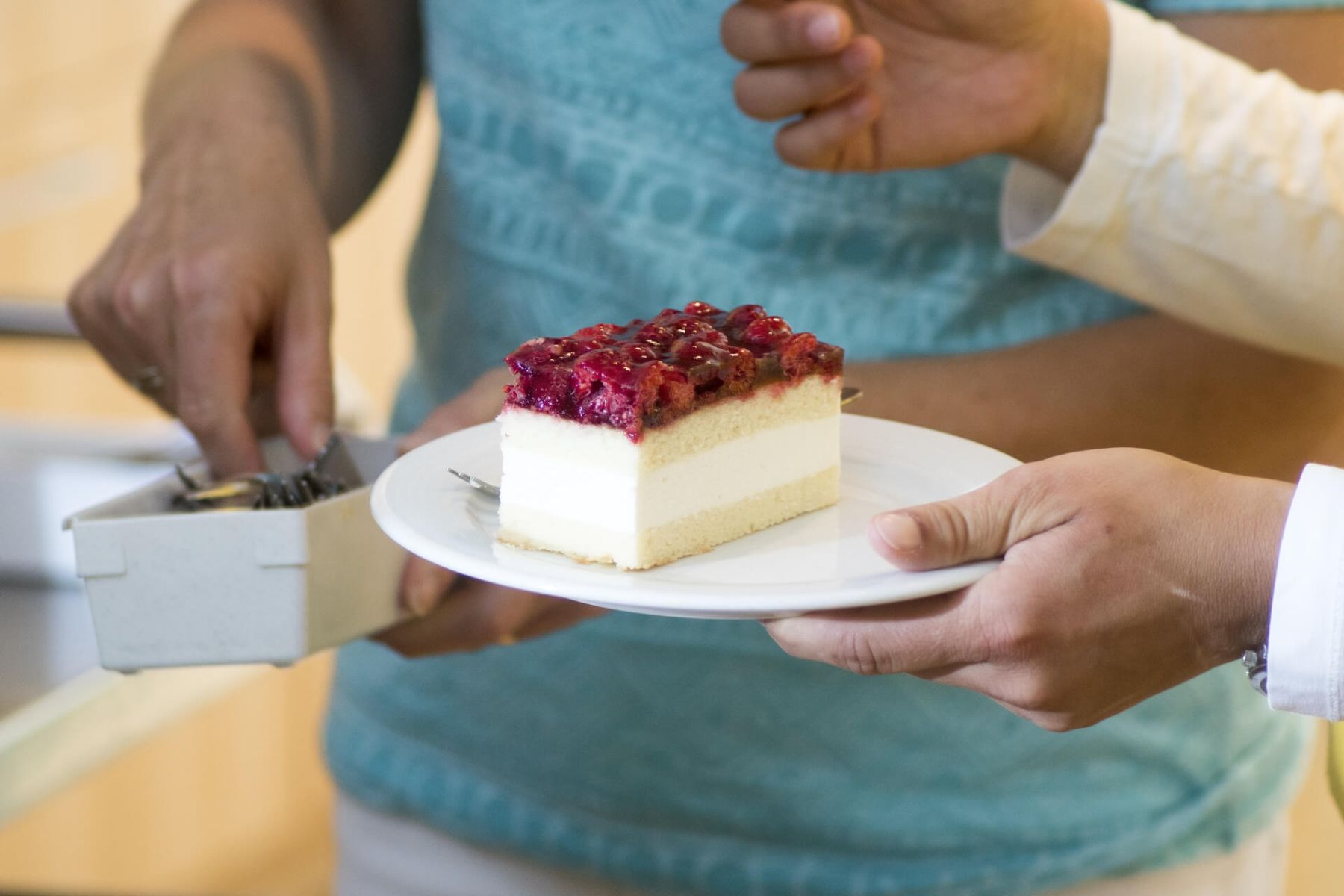 Ein Stück Sahne-Kirsch-Kuchen wird auf einem Teller serviert.
