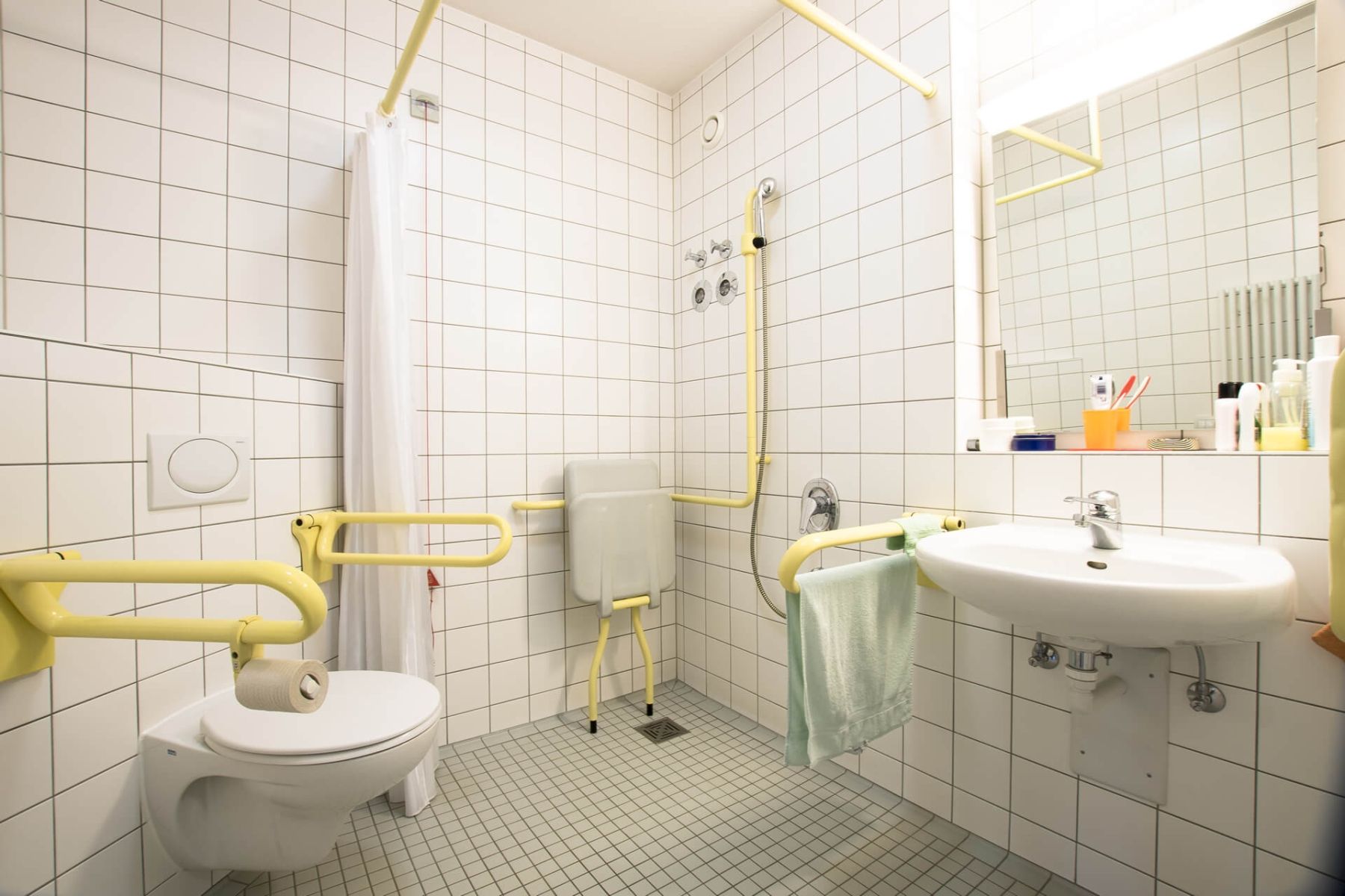 Barrierefreies Badezimmer mit Haltegriffen und bodengleicher Dusche.