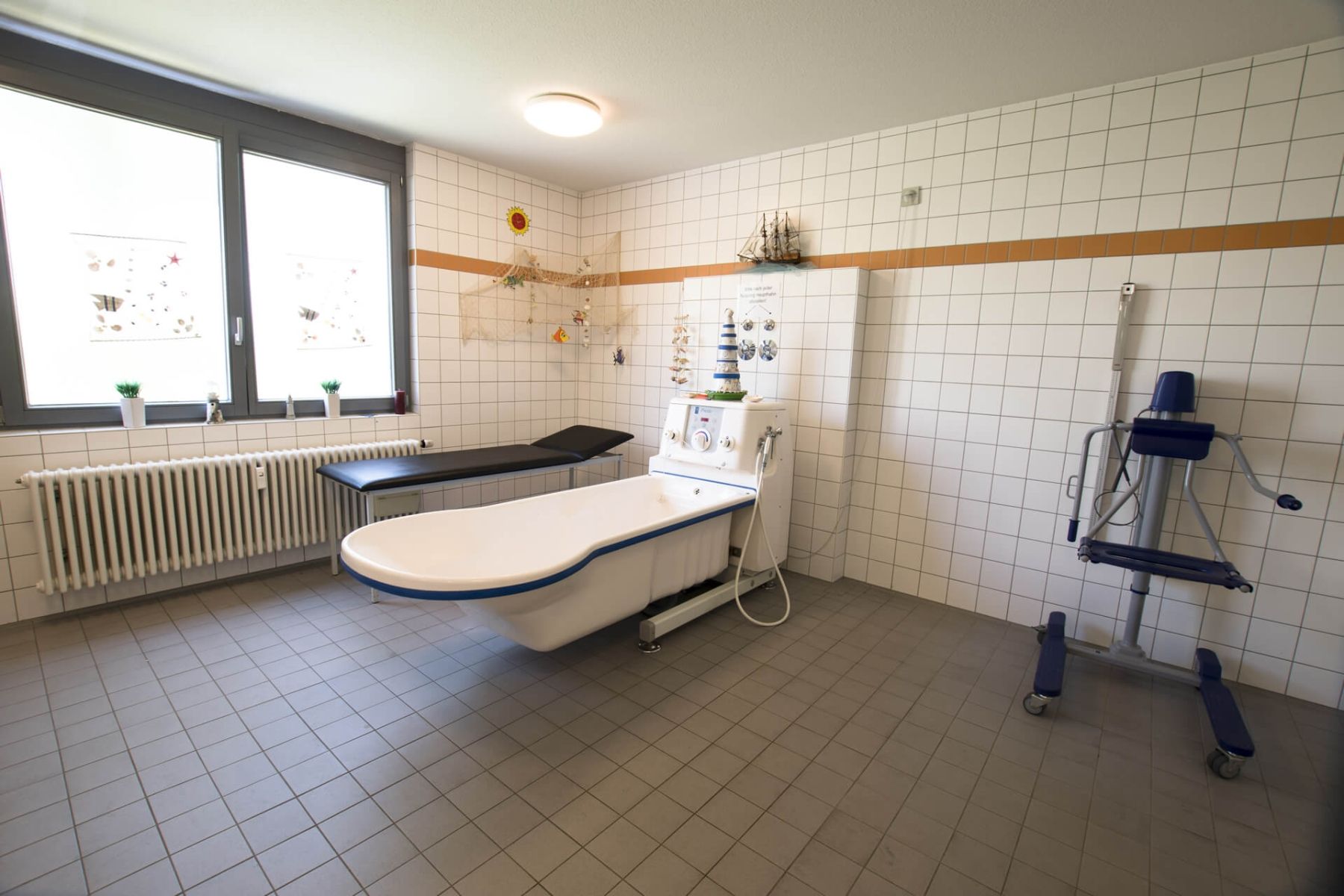 Pflegebad mit Spezialbadewanne, Liege und Lifter für körperlich eingeschränkte Personen.